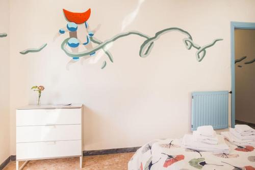 a bedroom with a bed with a branch decal on the wall at Un letto a Gaeta - Appartamento a Serapo via Bologna in Gaeta