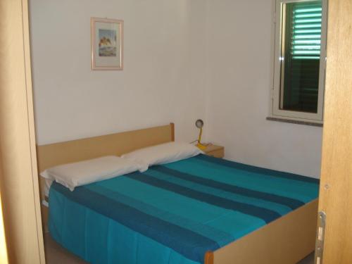 Un pat sau paturi într-o cameră la Porto Ottiolu