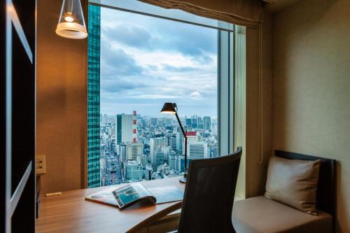 a desk with a view of a city from a window at The Royal Park Hotel Iconic Tokyo Shiodome in Tokyo