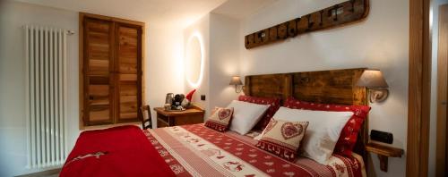 a bedroom with a bed with red and white pillows at Romantica camera in Valtournenche