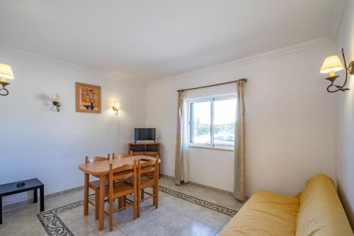 a living room with a table and a couch at Torre da Aldeia by Umbral in Albufeira