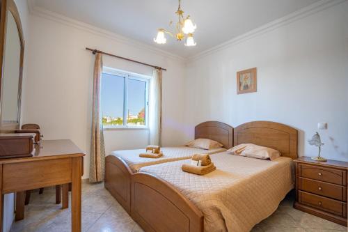 1 dormitorio con cama, escritorio y ventana en Torre da Aldeia by Umbral, en Albufeira