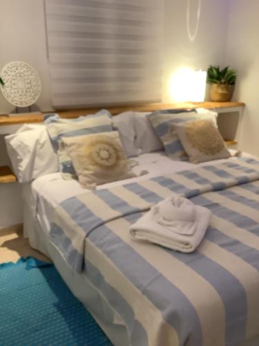 a blue and white bed with two towels on it at Apartamento Playa Denbossa in Playa d'en Bossa