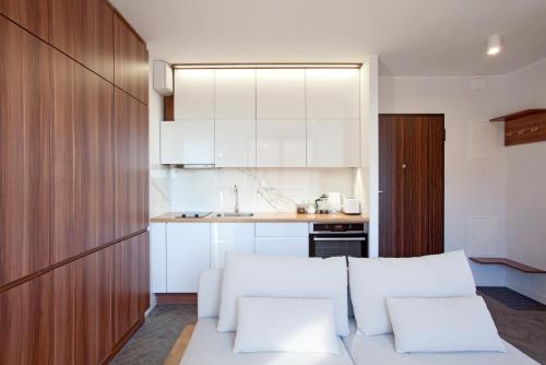 uma cozinha com armários brancos e um sofá branco em Marine Studio by Tyzenhauz em Gdansk