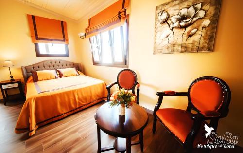 a bedroom with a bed and a table and a chair at SOFIA BOUTIQUE HOTEL in Kérynia