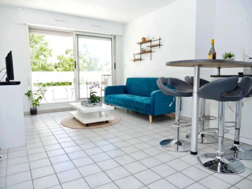 un salon avec un canapé bleu et une table dans l'établissement Appartement terrasse panoramique Hôpitaux et Facultés, à Montpellier