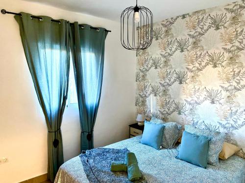 a bedroom with a blue bed with blue pillows at Casa El Barranco By Solymar Holiday in Vélez-Málaga
