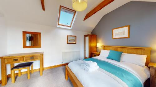 a bedroom with a large bed with a desk and a chair at Barker Stakes Farm in Pickering