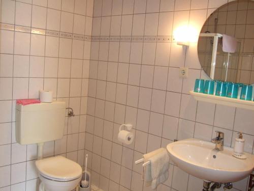 ein weißes Bad mit einem WC und einem Waschbecken in der Unterkunft Ferienhof Nickelswarft Fewo 2 in Poppenbüll