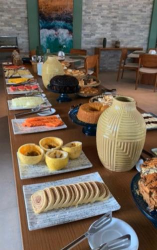 ein langer Tisch mit vielen verschiedenen Arten von Lebensmitteln in der Unterkunft Porto Beach Resort - Mana Beach Experience in Porto De Galinhas