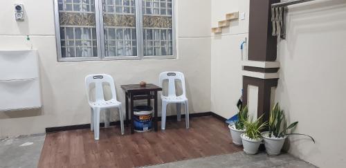 two white chairs sitting next to a table in a room at HomestayMuslim Safiyya in Sungai Petani