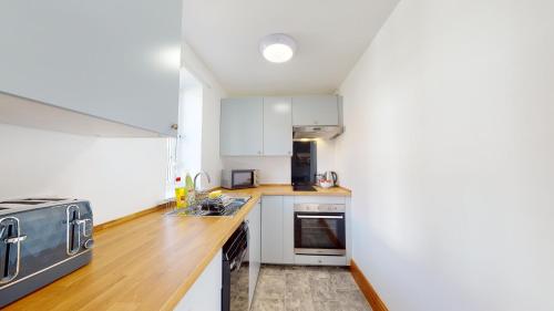 a kitchen with white cabinets and a wooden counter top at Barker Stakes Farm in Pickering
