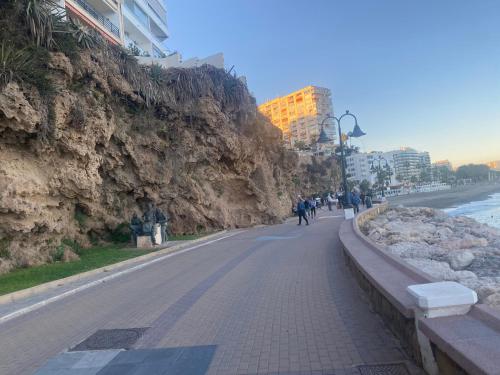 a road next to a rock wall next to the ocean at TERRAZAS DEL MAR with POOL in Torremolinos