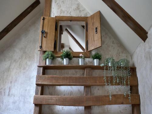 a wooden shelf with potted plants and a mirror at Holiday Home Anka in Gospić