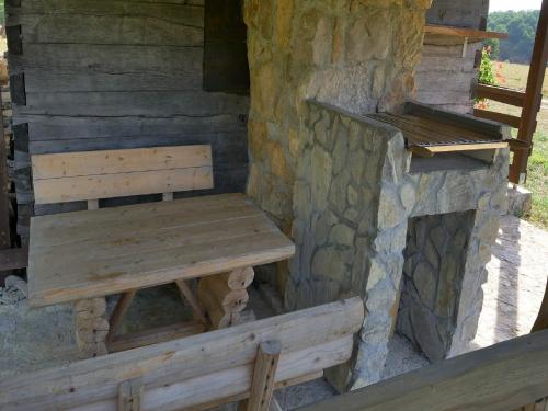 a wooden bench sitting in front of a stone wall at Holiday Home Anka in Gospić