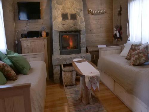 a living room with two beds and a fireplace at Holiday Home Jela in Gospić