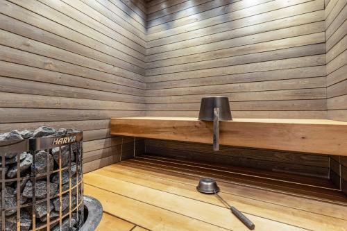 eine Sauna mit einer holzgetäfelten Wand und einem Regal in der Unterkunft SkyVillas B29 in Kalajoki
