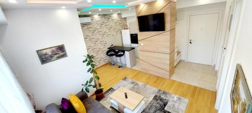 a view of a living room with a couch and a tv at Extra Apartman in Banja Luka