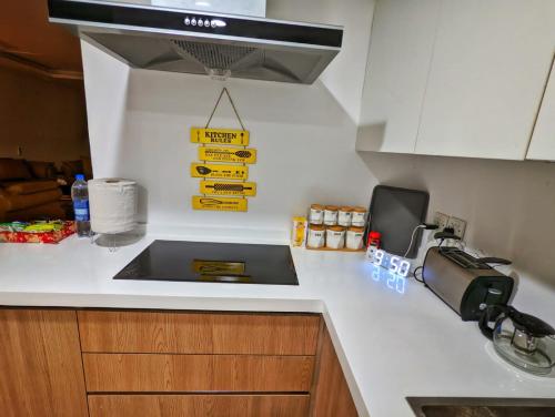 a kitchen counter with a sink and a sign on the wall at Sun-Rise view Luxury apartment Gold Crest Mall in Lahore