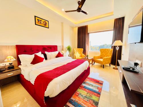 a bedroom with a bed and a desk and a television at Gange Blossam, Haridwar in Haridwār