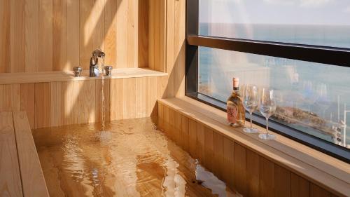 zalany pokój z oknem i butelką wina w obiekcie The Van Hotel w mieście Ulsan