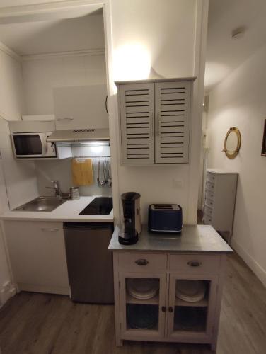 Il comprend une petite cuisine avec un évier et un comptoir. dans l'établissement Studio - Phalènes proche CID, à Deauville