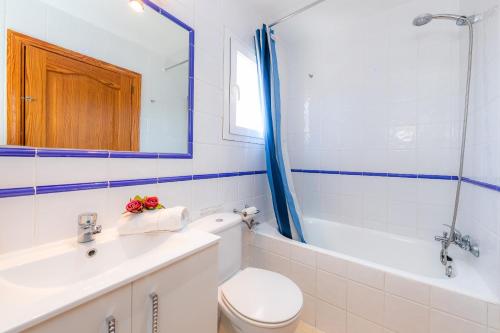 a bathroom with a toilet and a sink and a mirror at Eulalia Beach in Can Picafort