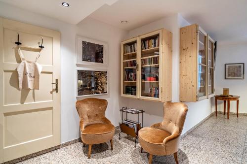 een kamer met 2 stoelen en een deur bij Domus Faber 3 in Merano