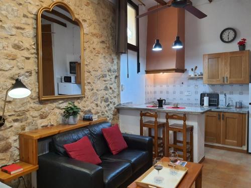 a living room with a couch and a kitchen at LA MUNTANYA - Apartamentos Rural Guadalest in Benimantell