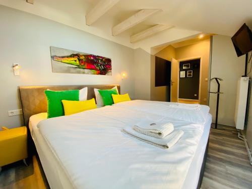 ヘリングスドルフにあるVilla Anna "3/4 Takt"のベッドルーム(大きな白いベッド、黄色と緑の枕付)