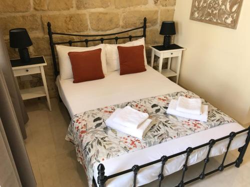 a bedroom with a bed with two night stands at The Cloisters Bed And Breakfast in Xagħra