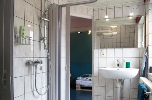 a bathroom with a sink and a shower with a mirror at Villa Kunterbunt - sehr zentral, neu renoviert, 2SZ in Wangen im Allgäu