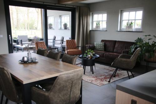 a living room with a table and a couch at Vrijstaand vakantiehuis Weideblik in Biezenmortel