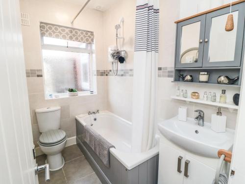 a bathroom with a tub and a toilet and a sink at Seaside House in Scarborough