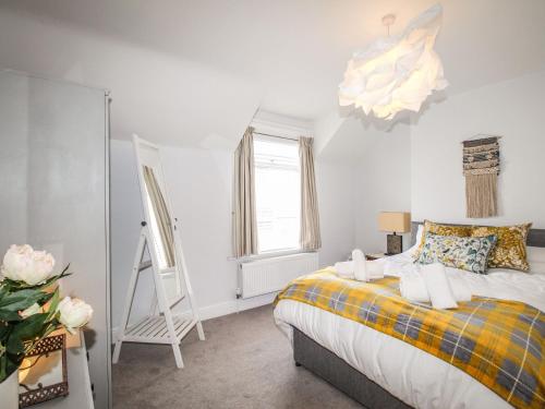 1 dormitorio con cama, ventana y espejo en Quarrier's Rest, en Swanage