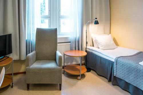 una camera con letto, sedia e TV di Hotelli Sointula a Orivesi