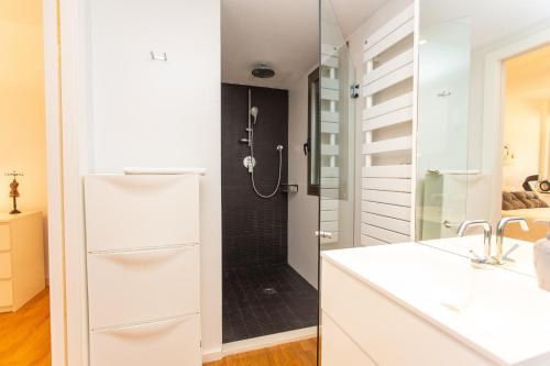 a white bathroom with a shower and a sink at Cullera Beach Apartment Cap Blanc in Cullera