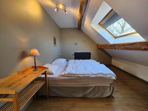 um quarto com uma cama num sótão com uma janela em Spacious holiday home in Wallonie with terrace 