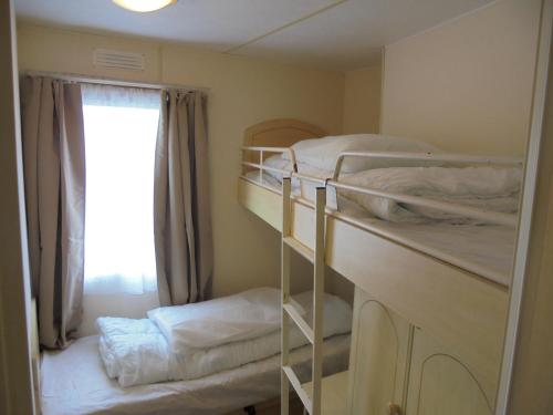 a room with two bunk beds and a window at 8 Berth on Coastfields (Everglade) in Ingoldmells