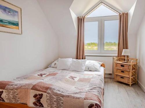 um quarto com uma cama e uma grande janela em Mesterki em Jastarnia