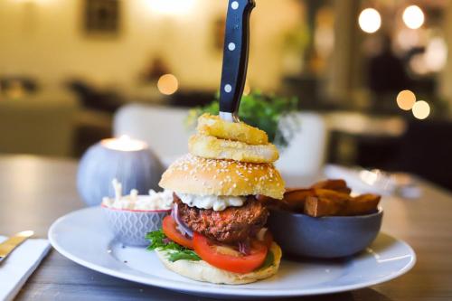 a sandwich with a knife on a plate with fries at Ardennan House Hotel in Inverurie