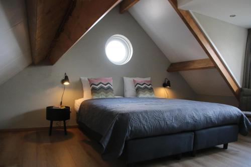a bedroom with a bed in a attic at Vrijstaand vakantiehuis Weideblik in Biezenmortel