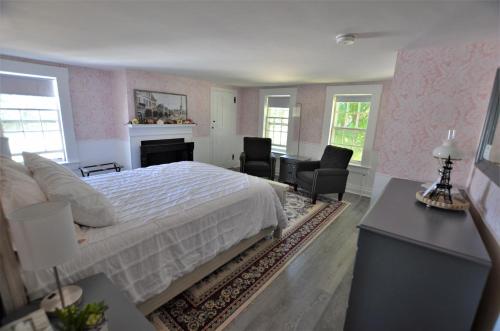 1 dormitorio con 1 cama, escritorio y sillas en Blue Bear inn, en Francestown