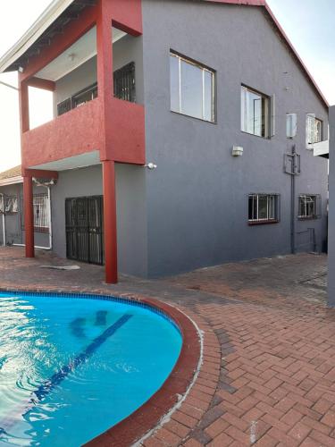 a house with a swimming pool in front of it at L-PACK PRIMROSe in Germiston