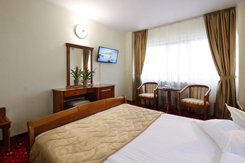 een hotelkamer met een bed, een tafel en een raam bij Hotel Moldova in Iaşi