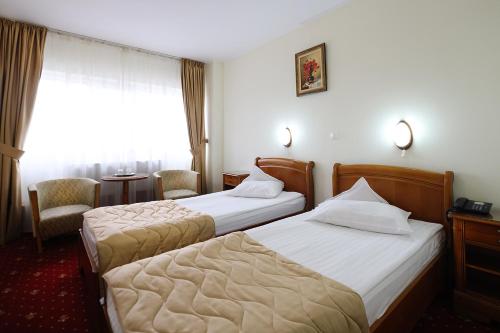 a hotel room with two beds and a window at Hotel Moldova in Iaşi