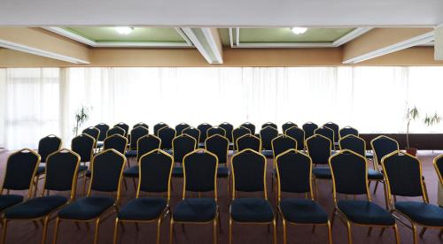 a room with rows of chairs and a podium at Hotel Moldova in Iaşi