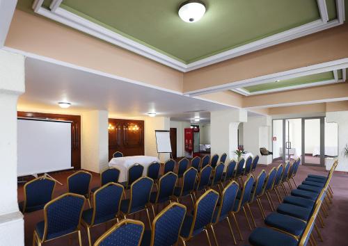 a conference room with chairs and a projection screen at Hotel Moldova in Iaşi