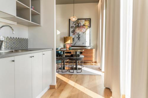 a kitchen with white cabinets and a table in a room at Fritiden Hotell & Kongress in Ystad