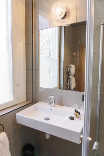 a bathroom with a white sink and a mirror at Fritiden Hotell & Kongress in Ystad